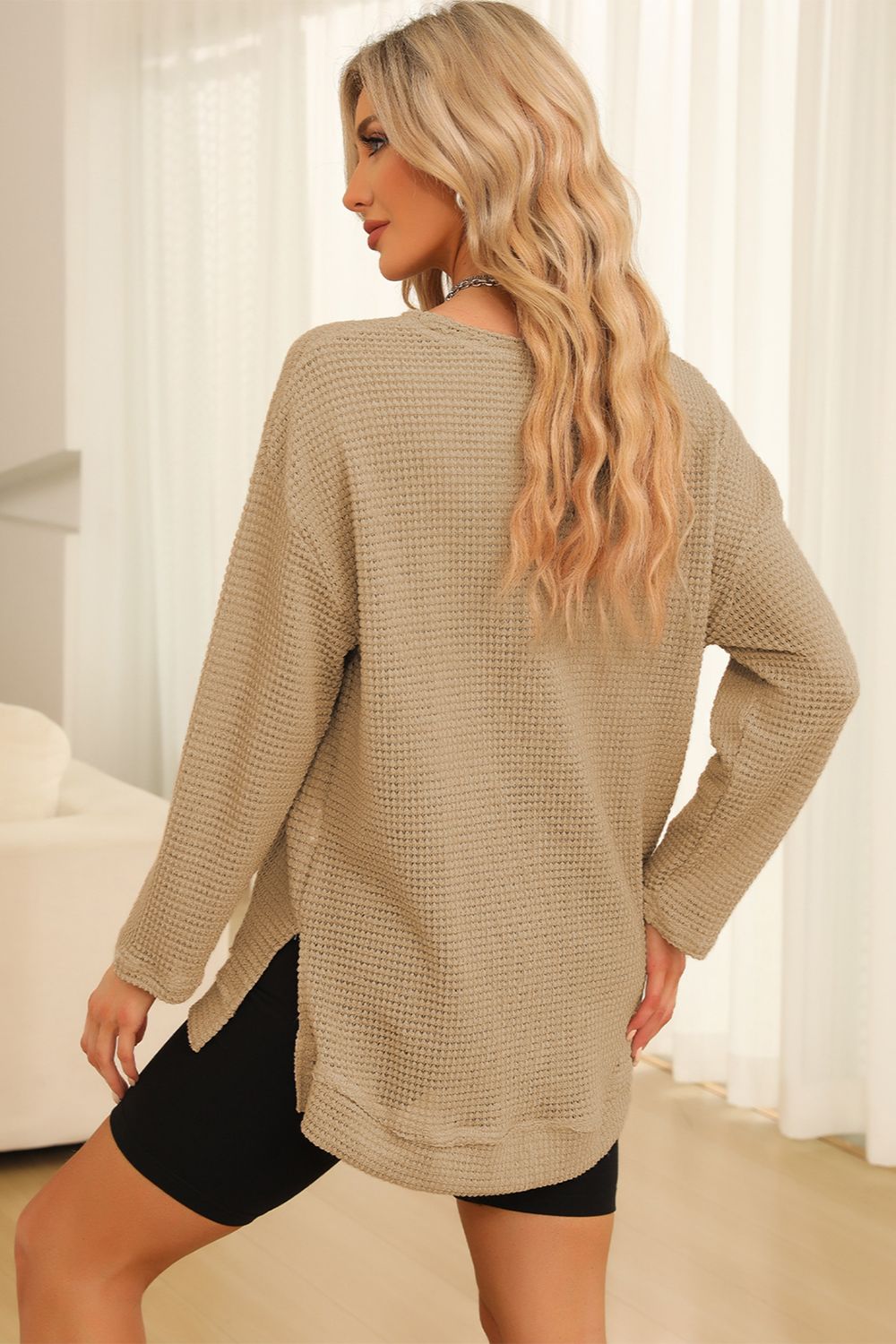 Tan waffle knit oversized top with slit hem and long sleeves.