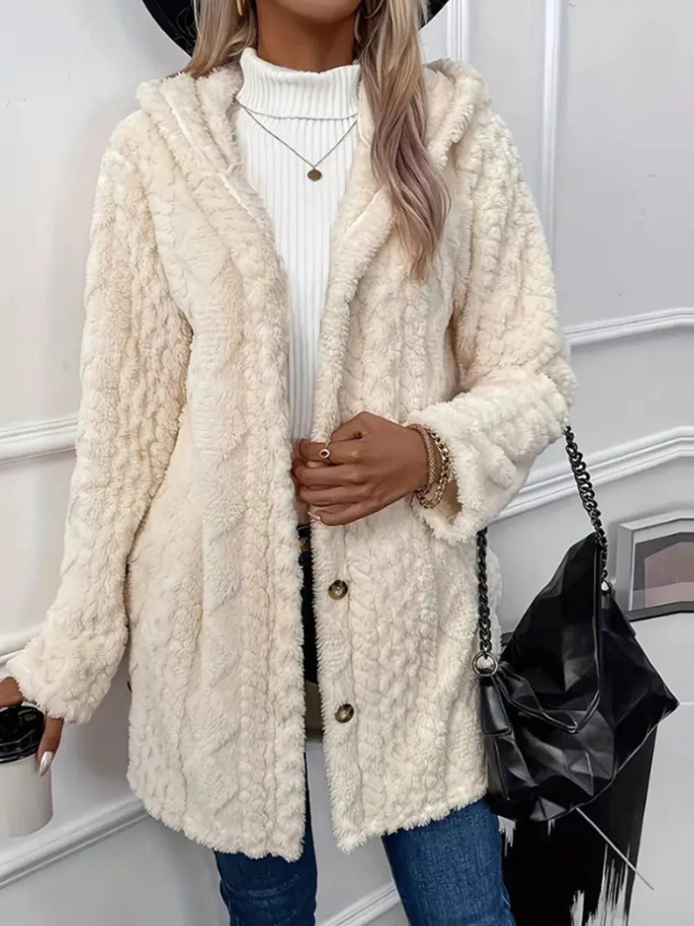 Cream fuzzy hooded trench coat with button detail and textured pattern.