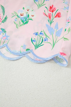 Pink midi dress with a colorful wildflower print and scalloped hem detail.