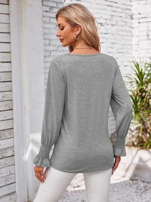 Gray blouson sleeve top with smocked cuffs and V-neck detail.