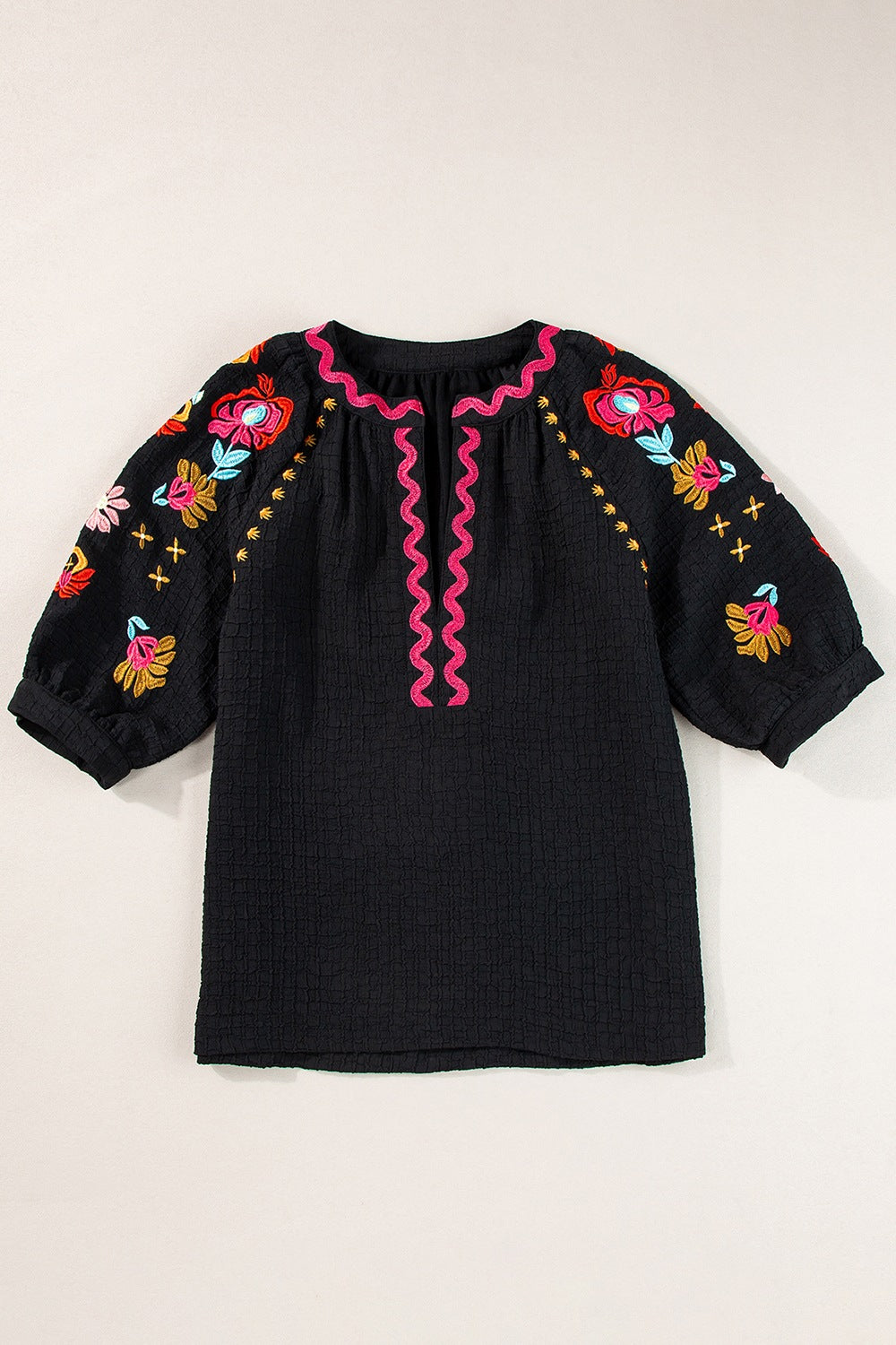 Black embroidered blouse with voluminous sleeves and pink neckline detail