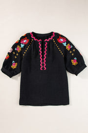 Black embroidered blouse with voluminous sleeves and pink neckline detail