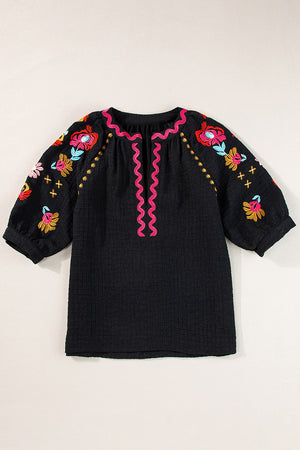 Black embroidered blouse with voluminous sleeves and pink neckline detail