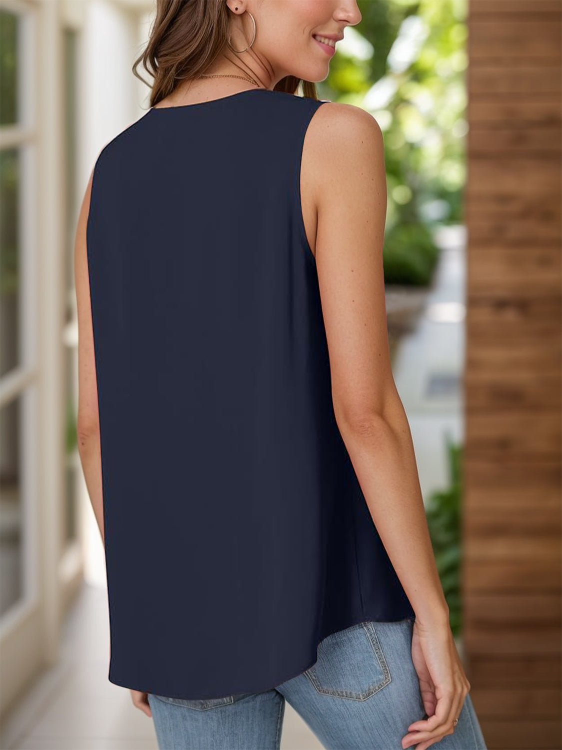 Navy sleeveless blouse with pleated front detail and a relaxed fit.
