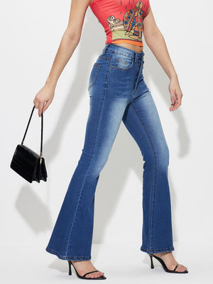 Mid-rise flare denim jeans in medium blue wash cotton, styled with a crop top and black handbag.