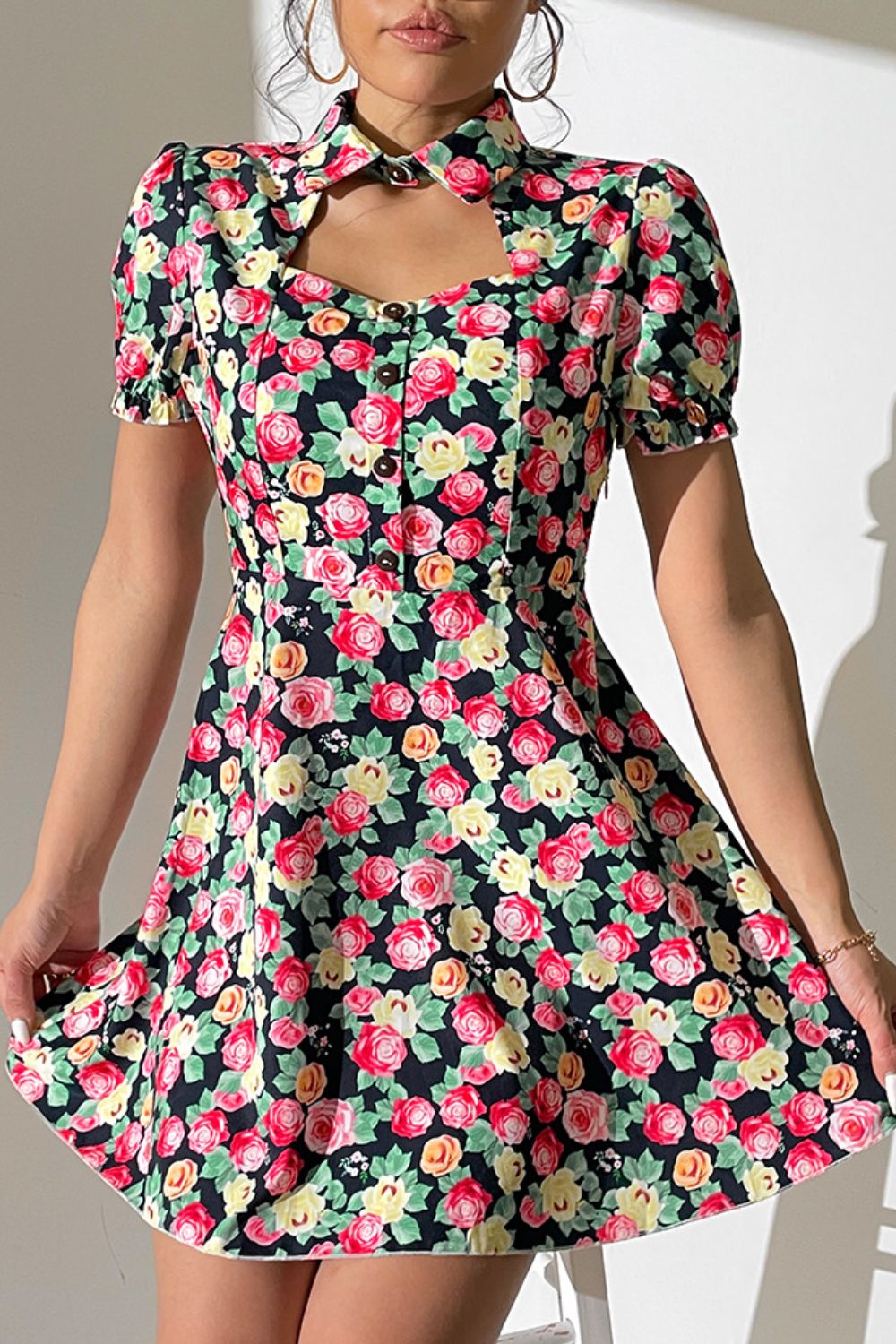 Floral mini dress with keyhole neckline, puff sleeves, and button front.