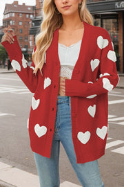 Red knit cardigan with white heart appliqués, button front, and ribbed cuffs.