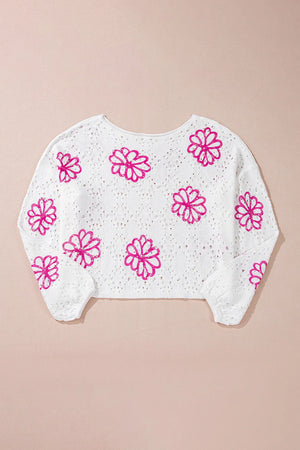 White eyelet knit pullover with pink floral embroidery and long sleeves.