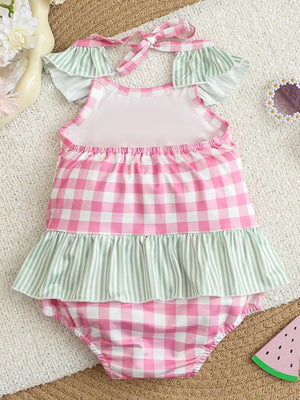 Pink gingham baby one-piece swimsuit with green striped ruffles and tie straps.