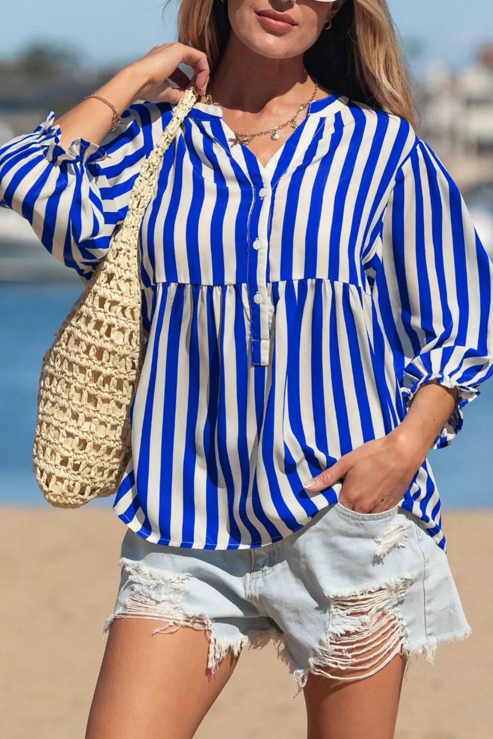 Blue and white striped button-down shirt with balloon sleeves and a tiered hem.
