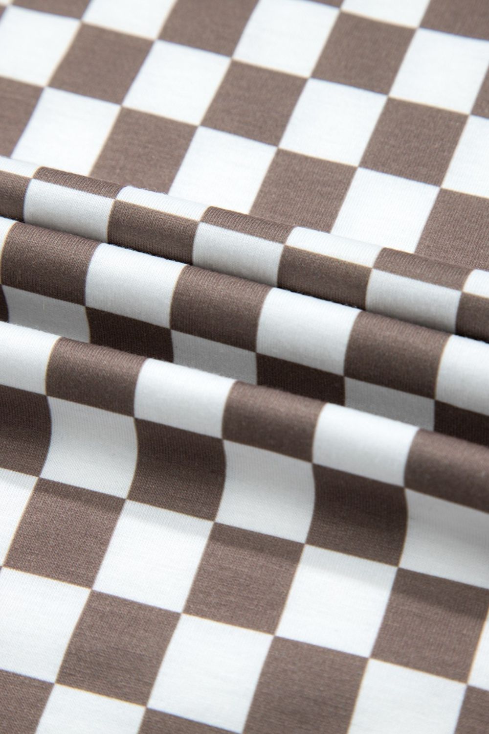 Checkered palazzo jumpsuit in mocha with cap sleeves, shown in a fabric detail view.