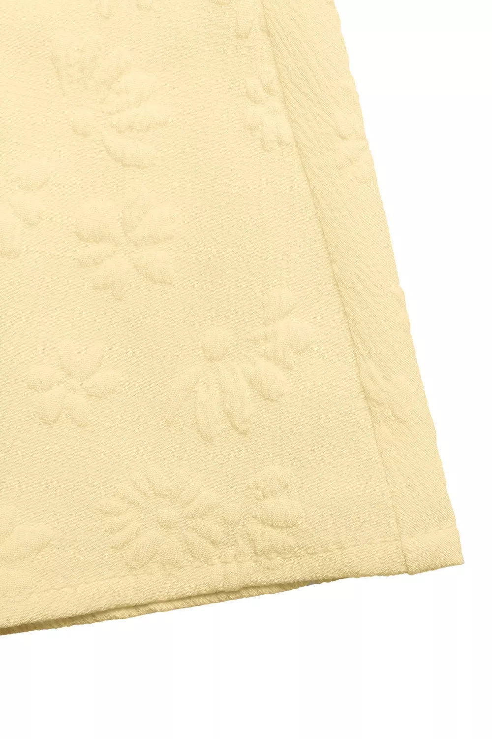 Yellow smocked floral maxi dress fabric detail with embossed flowers.