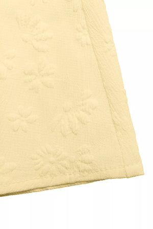 Yellow smocked floral maxi dress fabric detail with embossed flowers.