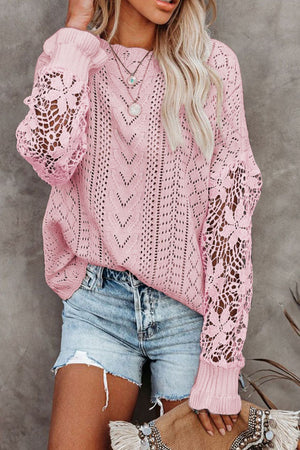 Pink openwork knit sweater with lace sleeves and chevron pattern.