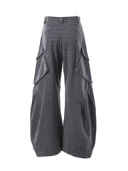 Dark gray textured paneled cargo pants with multiple flap pockets and a baggy fit.