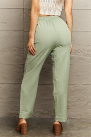 Light green utility drawstring trousers with vertical texture and cuffed hems.