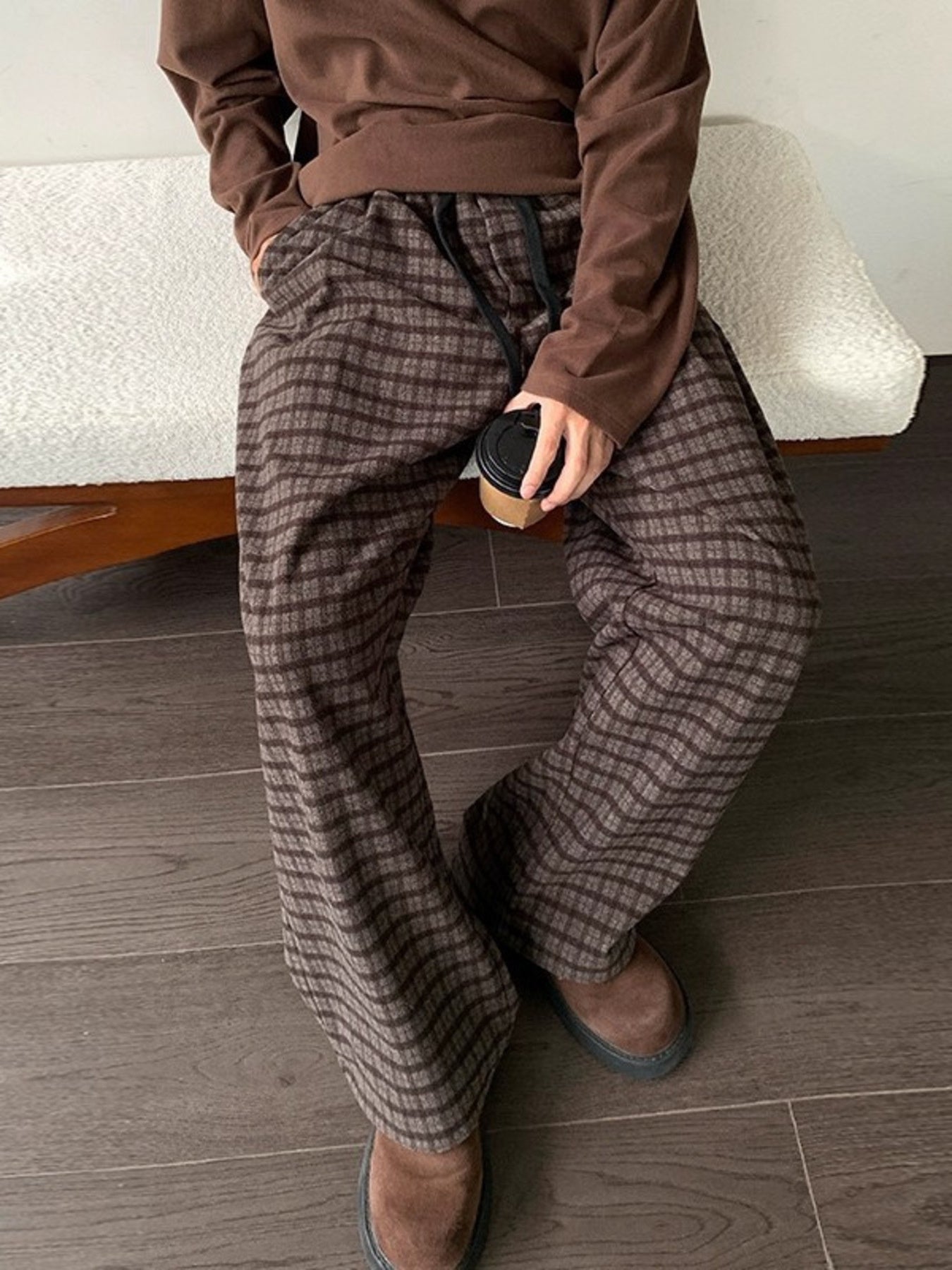 Men's brown plaid wide leg trousers with drawstring waist.
