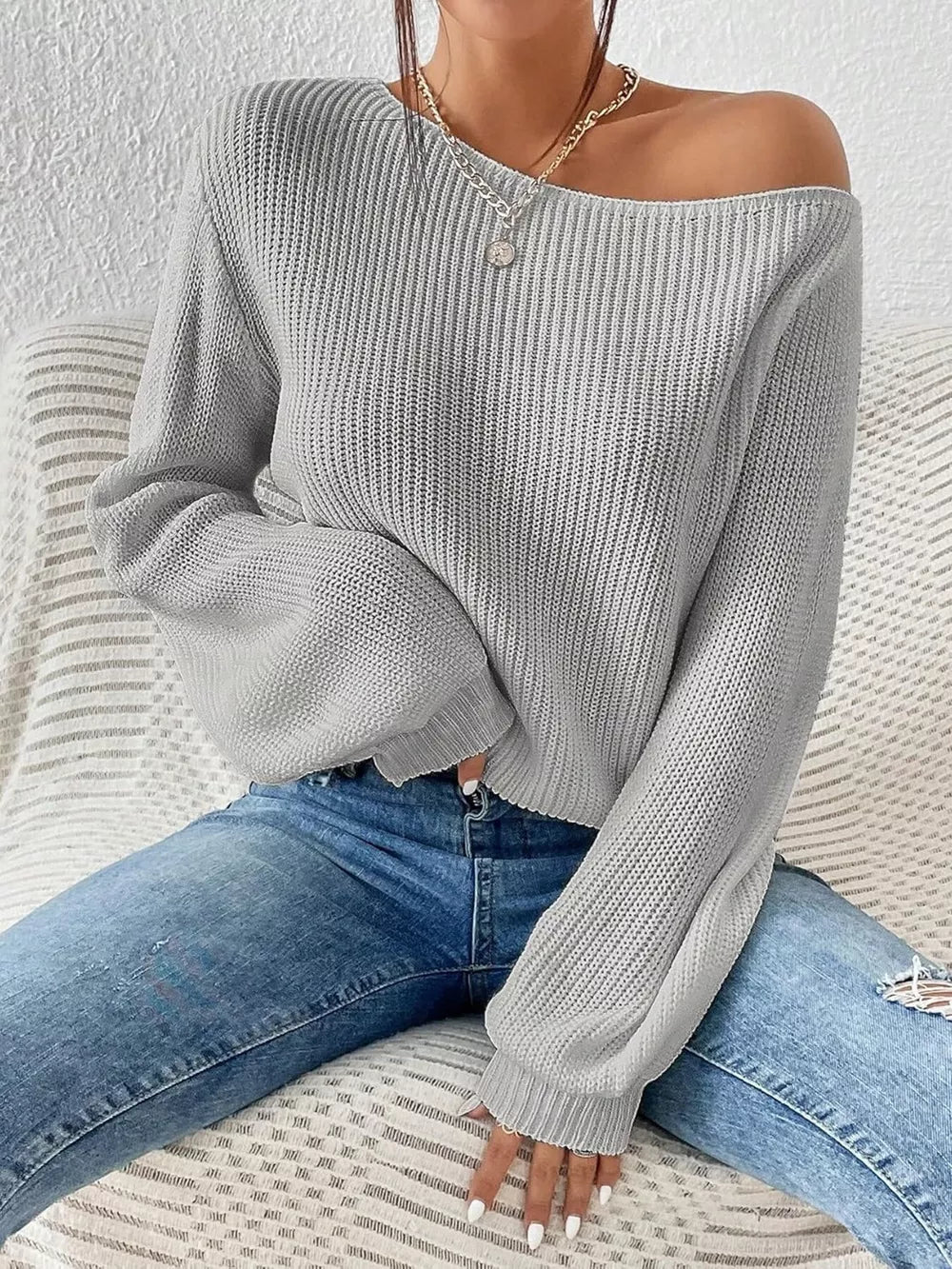 Light gray asymmetrical knit sweater with off-shoulder neckline and balloon sleeves.