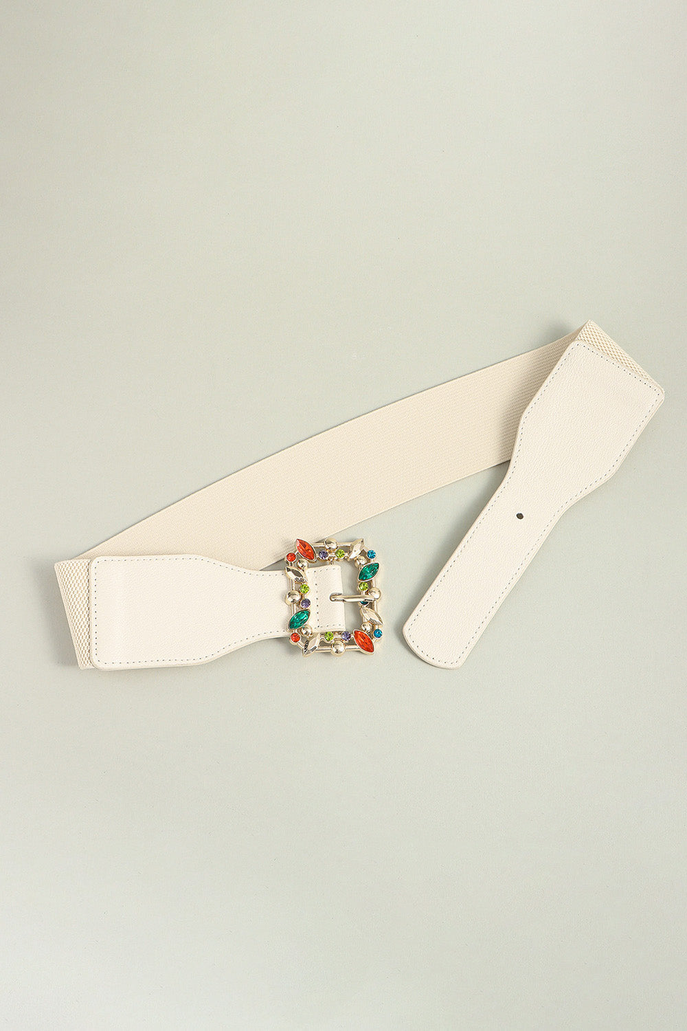 Ivory elasticated belt with jeweled buckle and faux leather trim.