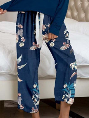 Dark blue botanical print lounge pants with white tie waist and relaxed fit.