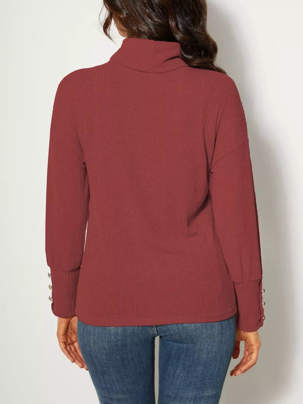 Brick red ribbed turtleneck knit tunic top with decorative buttons on cuffs.