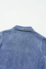 Medium wash denim romper with button-down collar and elastic waist detail.