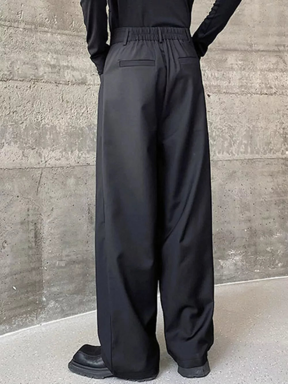 Black men's wide-leg dress pants with elastic waist and back pockets.