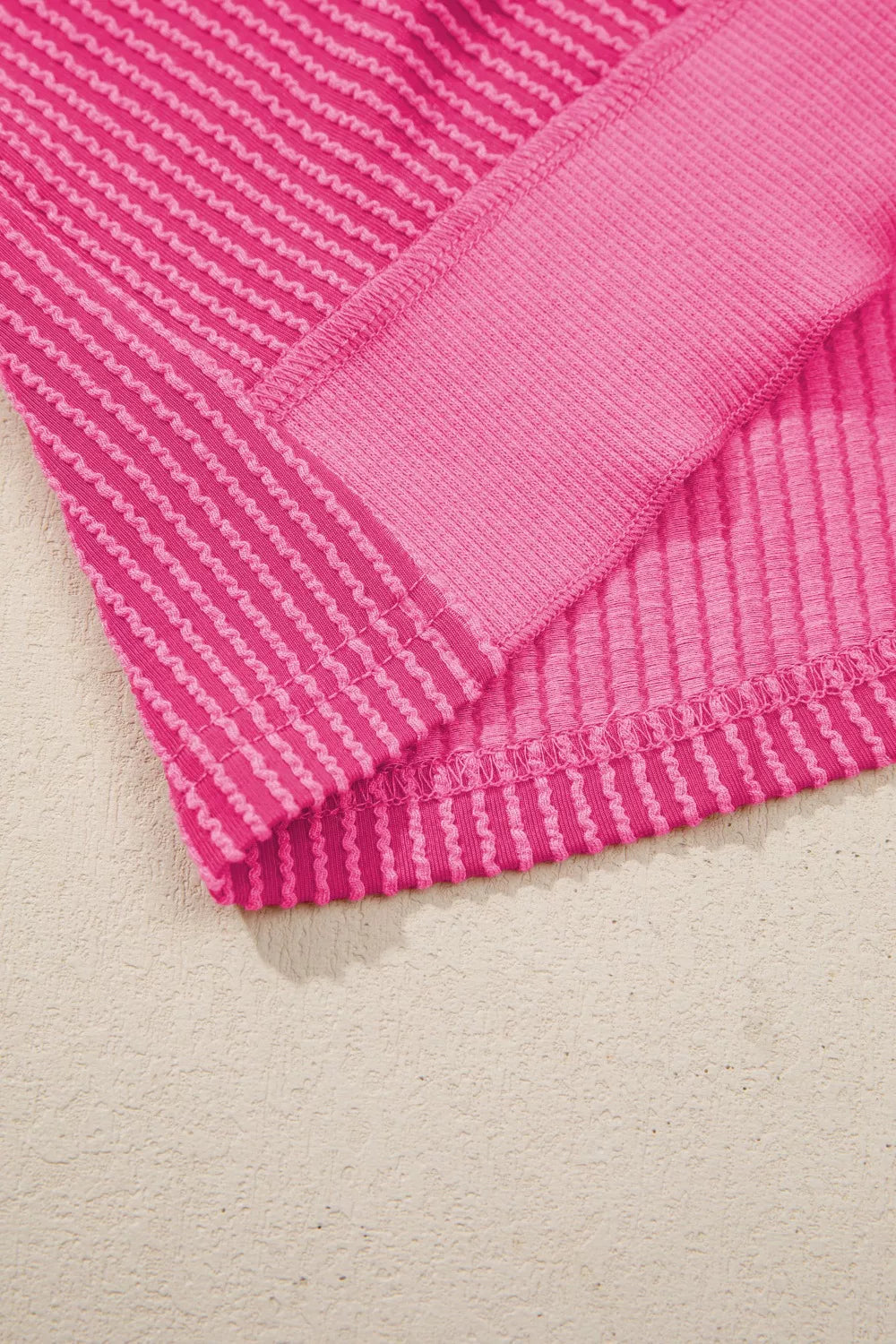 Pink ribbed maternity t-shirt with contrasting band detail and wavy hem.