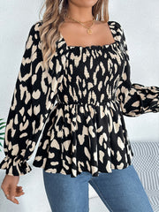Black smocked bodice square neck blouse with abstract print and ruffled cuffs.