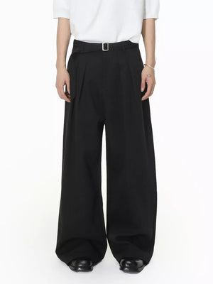 Black wide-leg pleated sweatpants with a belt and silver buckle.