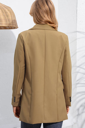 Tan double-breasted blazer with flap pockets and buttoned cuffs.