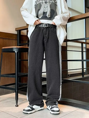 Men's black oversized wide-leg jeans with white side stripes.