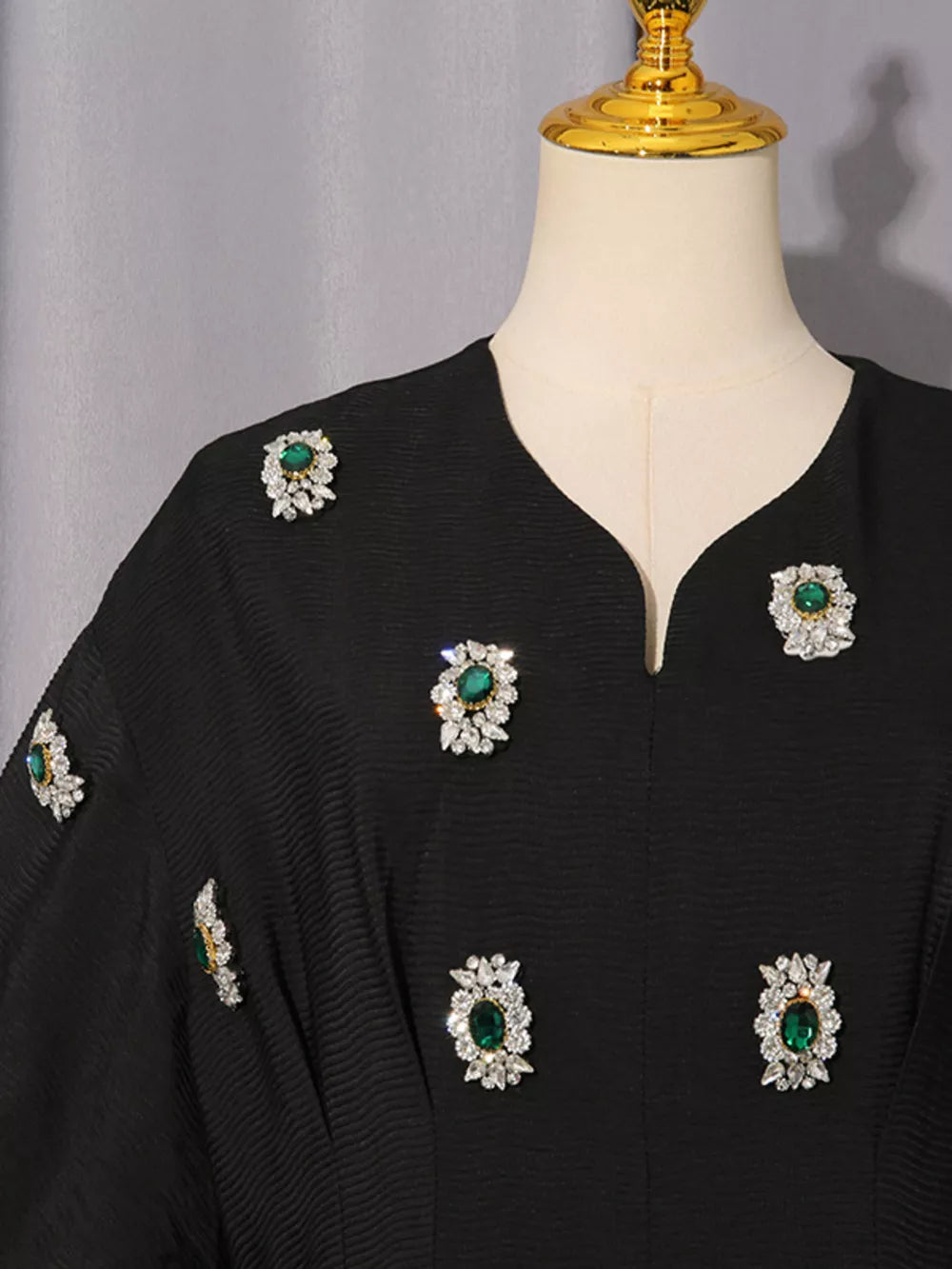 Black midi dress with V-neck and scattered emerald rhinestone embellishments.