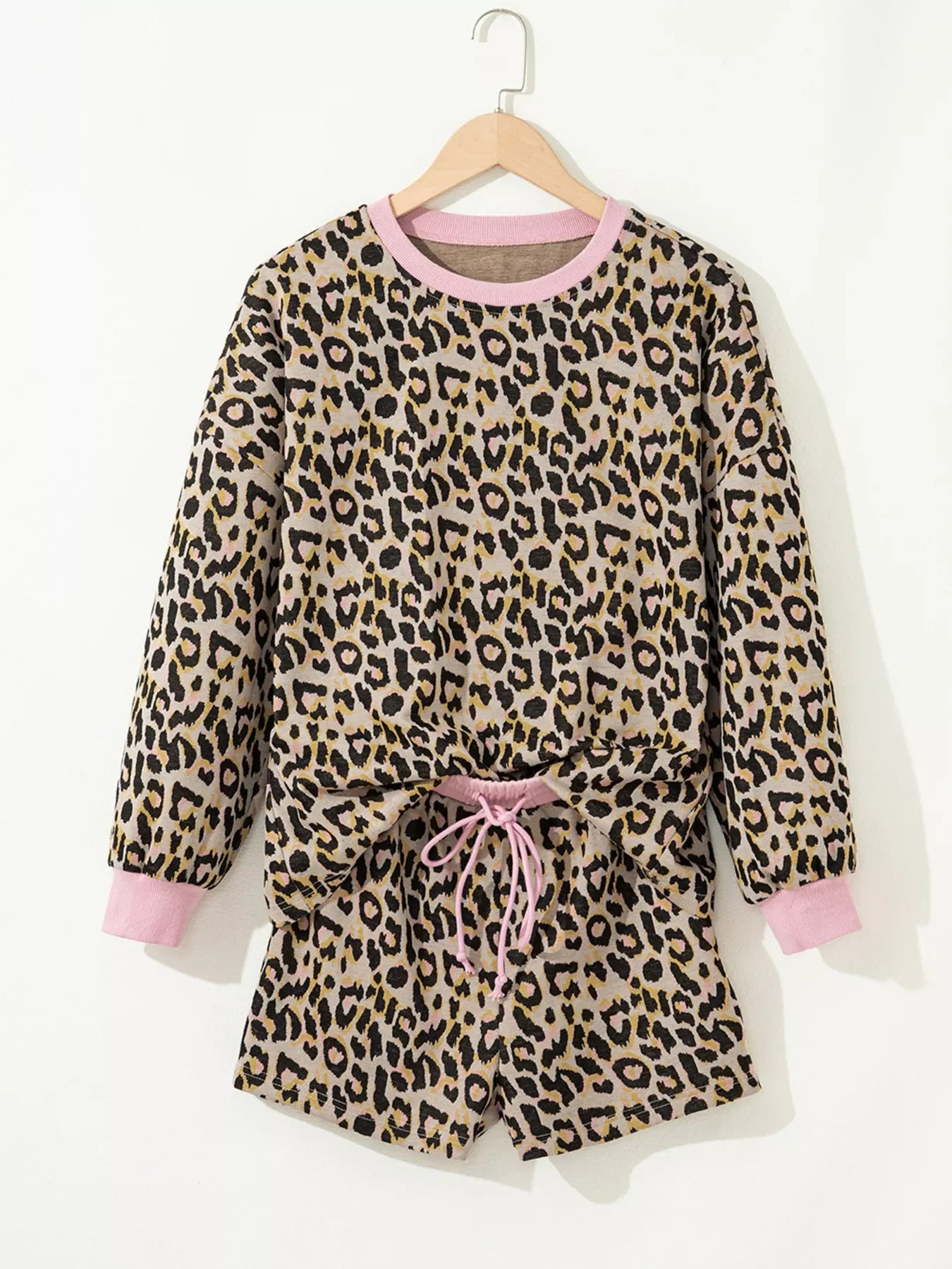 Leopard print loungewear set with pink trim, crew neck sweatshirt and drawstring shorts.