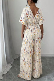 Floral pleated wide-leg jumpsuit with cinched waist and V-neck.