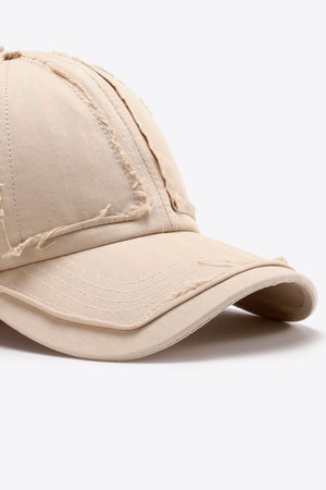 Camel baseball cap with raw edge denim details and visible stitching.