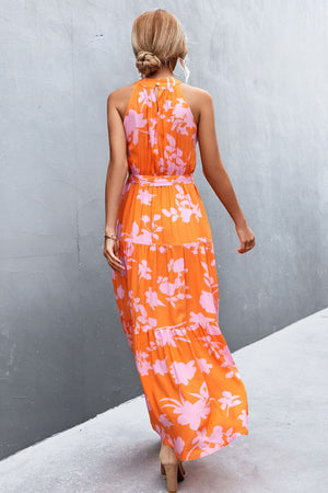 Orange floral print maxi dress with halter neckline and tiered skirt.