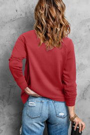 Scarlet raglan sweatshirt with long sleeves and a crew neck.
