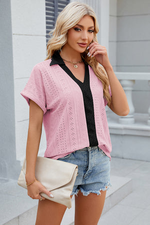 Perforated pink polo top with black collar and V-neck, short sleeves.