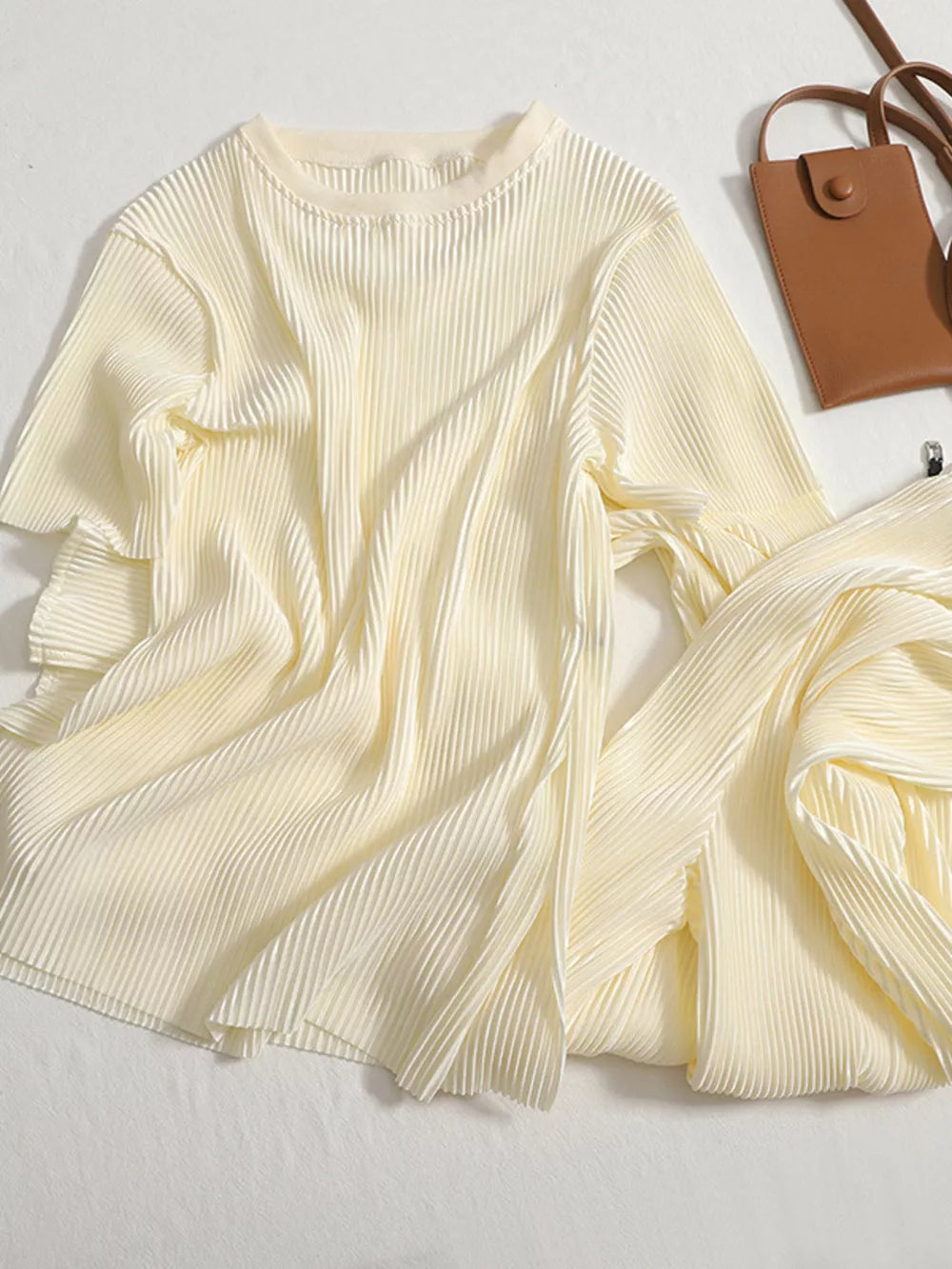 Apricot pleated two-piece set with round neck top and flowing pants.