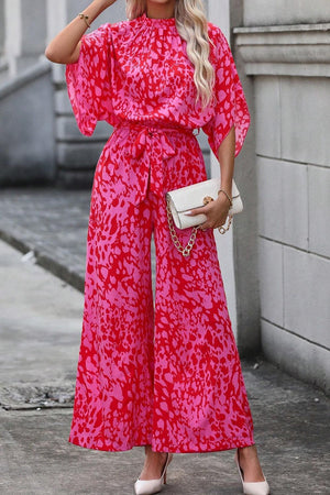 Crimson Splatter Tie-Waist Palazzo Jumpsuit in hot pink with wide legs and dolman sleeves.