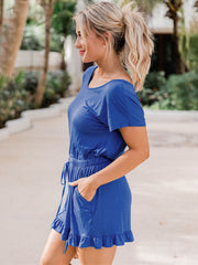 Royal blue romper with short sleeves, drawstring waist, ruffled hem and pockets.
