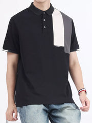 Black cotton polo with asymmetrical color-block detail on chest and sleeves.