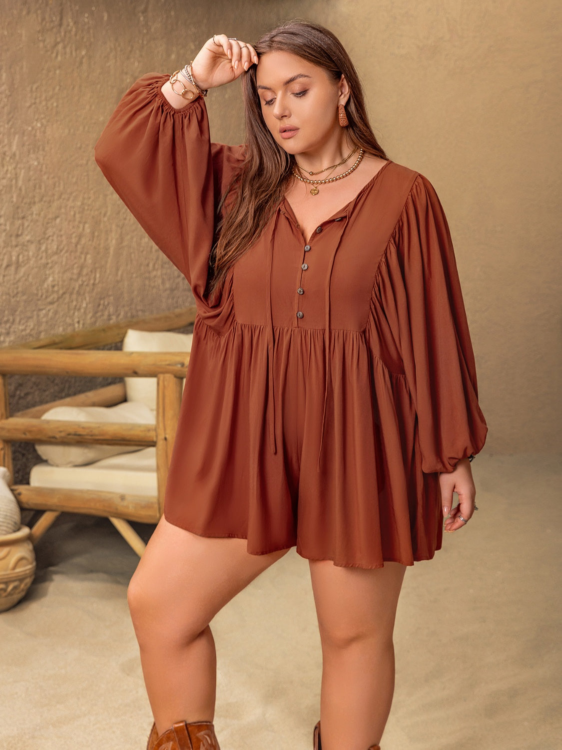 Caramel tiered romper with voluminous sleeves, buttoned v-neck and tie detail.