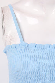 Light blue smocked bodice palazzo jumpsuit with thin straps and ruffled neckline detail.