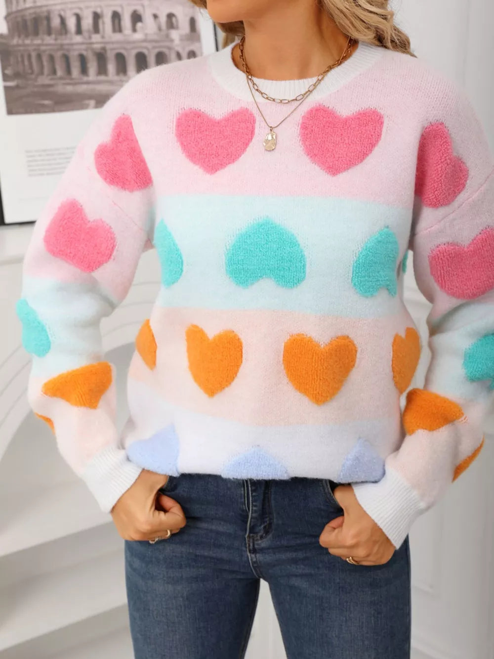 Fuzzy knit sweater with colorful heart pattern, crew neck, long sleeves, and cozy acrylic blend.