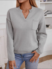 Gray knit sweater with notched neckline and chest pocket, long sleeves.