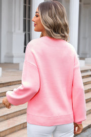 Blush pink acrylic intarsia knit sweater with a graphic bow detail.