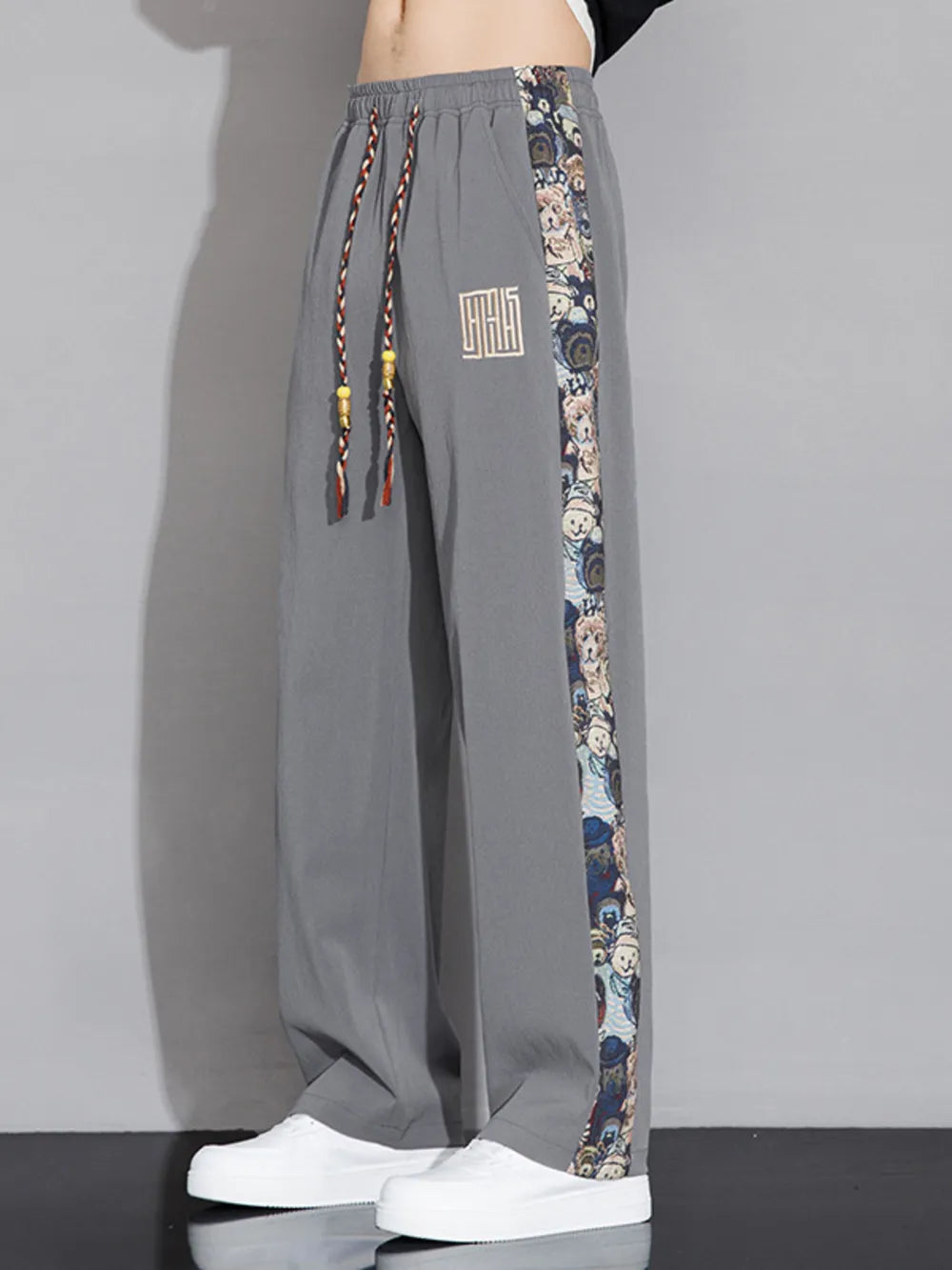 Men's light gray sweatpants with printed side stripe and drawstring waist.