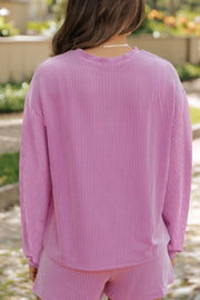 Pink textured loungewear set with vertical stripes and crew neck.